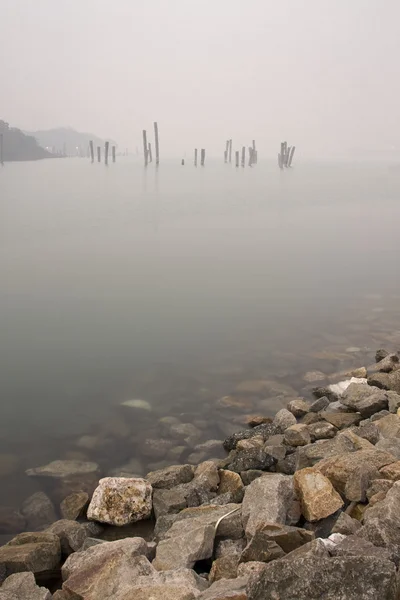 Madeira na água em névoa — Fotografia de Stock
