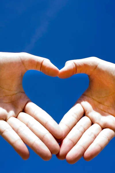 Coração combinado de mãos no fundo azul — Fotografia de Stock