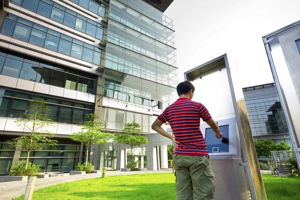 Asia boy play the touch screen in modern building outside — Stock Photo, Image