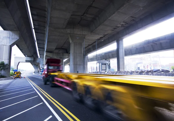 Container carro em movimento rápido sob a ponte da auto-estrada — Fotografia de Stock