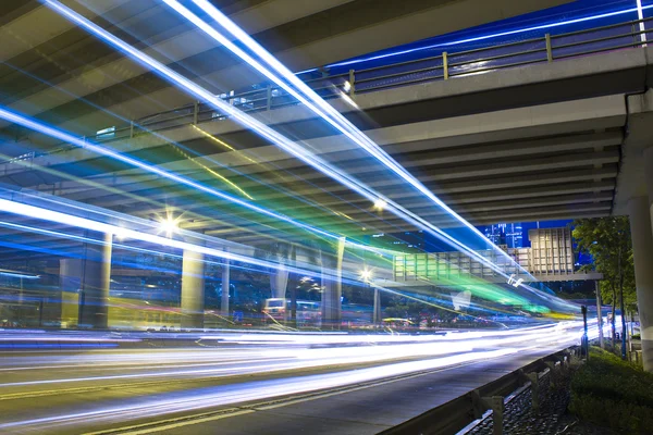Auto-estrada à noite com carros de luz na cidade moderna . — Fotografia de Stock