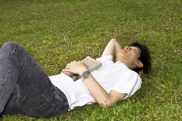 Ásia homem relaxar na grama — Fotografia de Stock