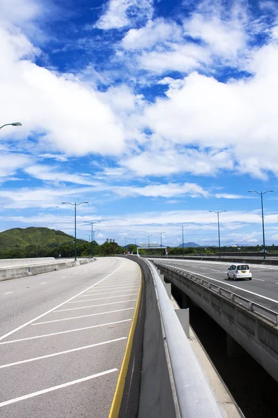 Vägen genom bron med blå himmel bakgrund av en stad. — Stockfoto