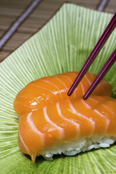 Sushi en eetstokjes op schijf — Stockfoto