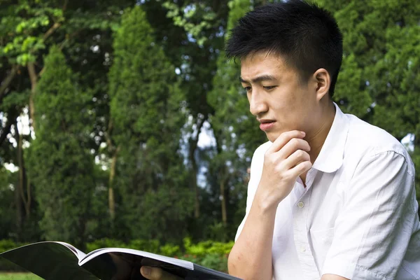 Młody student, czytanie książki w szkole park — Zdjęcie stockowe