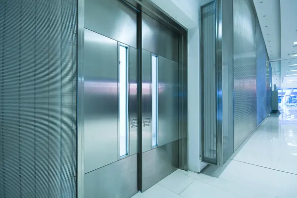 Big steel door in office building with long corridor — Stock Photo, Image