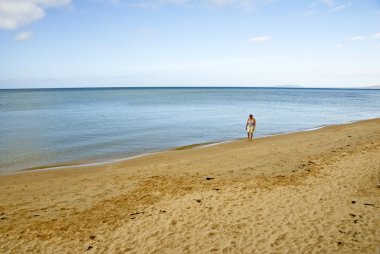 mujer sola en la playa de arena