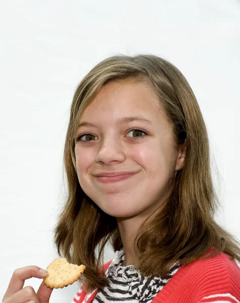 Fiatal lány, egy keksz evés — Stock Fotó