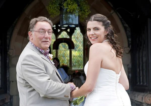 Bruid en haar vader bij de kerkdeur — Stockfoto