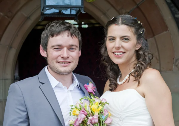 Bruid en bruidegom buiten kerkdeur — Stockfoto