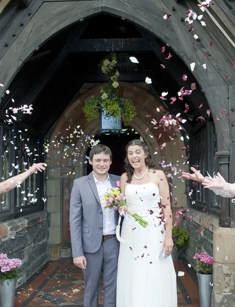 Bruid en bruidegom met confetti gegooid — Stockfoto