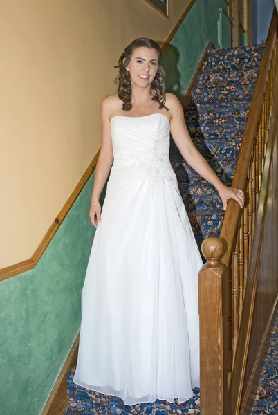 Невеста в свадебном платье спускается по лестнице — стоковое фото