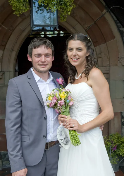 Noiva e noivo fora da porta da igreja — Fotografia de Stock