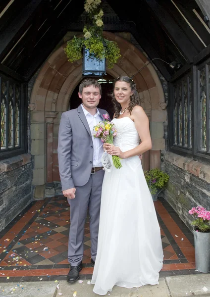 Noiva e noivo fora da porta da igreja — Fotografia de Stock