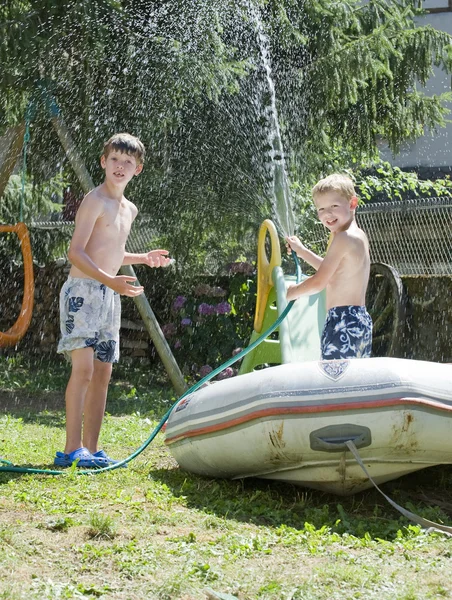 Deux jeunes garçons jouent avec tuyau d'arrosage — Photo
