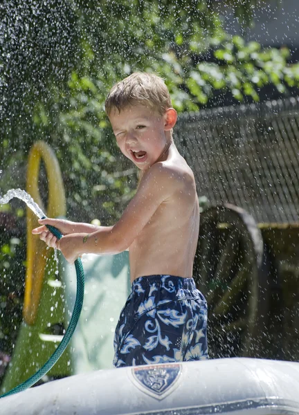 stock image Young boy playing with hose pipe