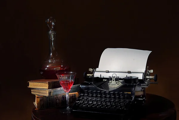 Natura morta con vecchia macchina da scrivere, caraffa di vino e vetro — Foto Stock