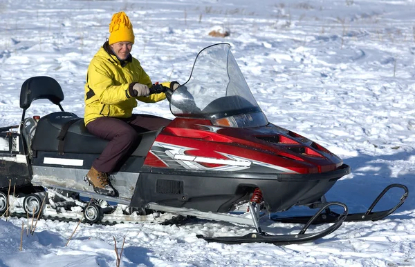 Girl in yellow on red snow scooter — Stock Photo, Image