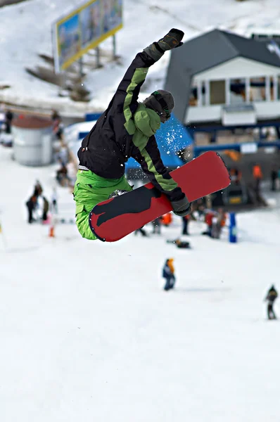 Grüne Snowboarderin extreme fly — Stockfoto