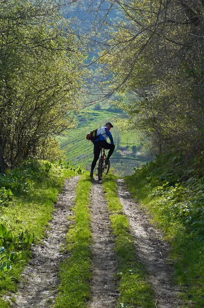 山区农村道路上骑自行车的人 — 图库照片