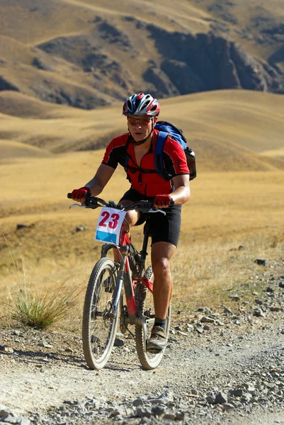 Ciclista de montaña en carrera por el desierto — Foto de Stock