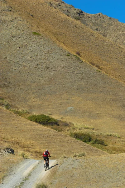 Ποδηλάτης στον δρόμο στο έρημο βουνό — Φωτογραφία Αρχείου
