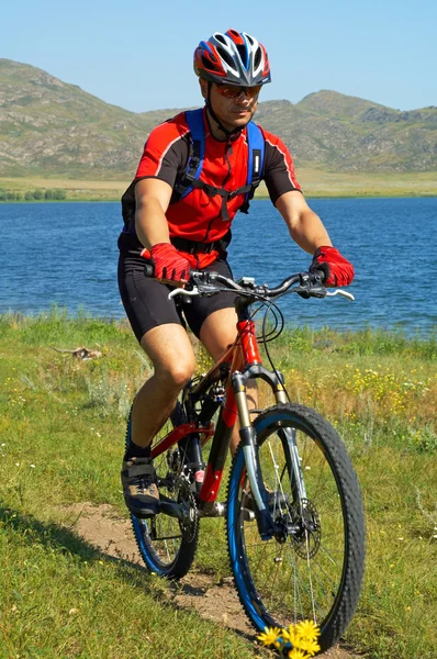 Bicicleta turística no campo verde ao lado do lago — Fotografia de Stock