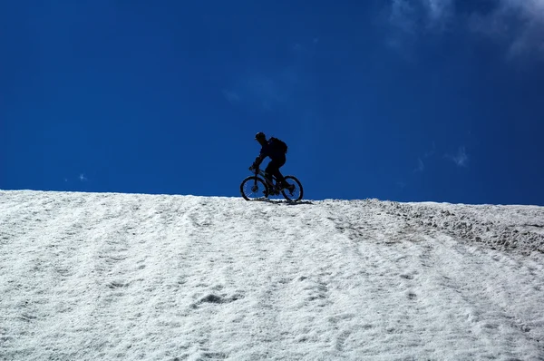 Cielo, nieve y ciclista de montaña — Foto de Stock