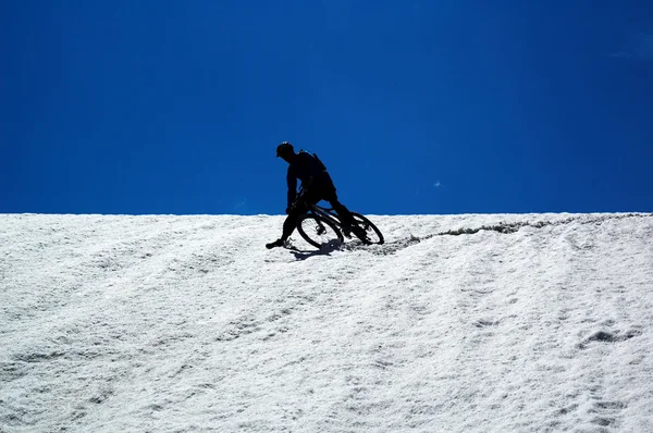 Cielo, nieve y ciclista de montaña — Foto de Stock