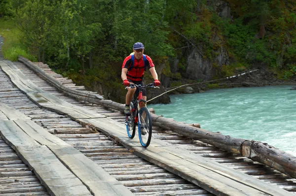 Montanha motociclista na ponte de madeira — Fotografia de Stock