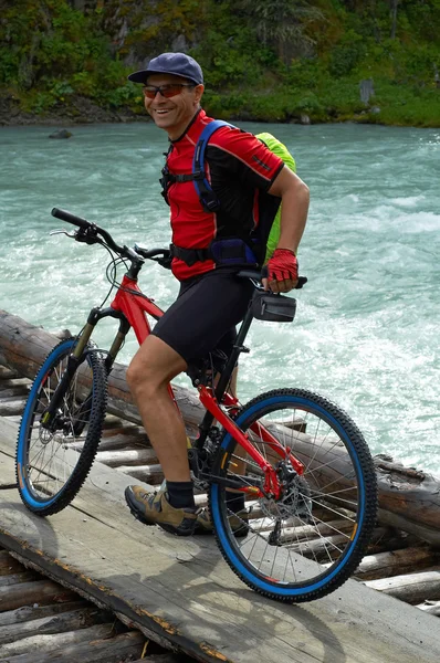 Mountain biker on wooden bridge — Stock Photo, Image