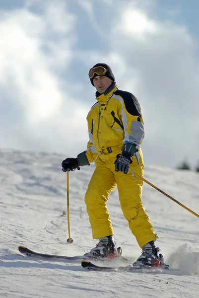 Žlutá hora lyžař na svahu ski resort — Stock fotografie