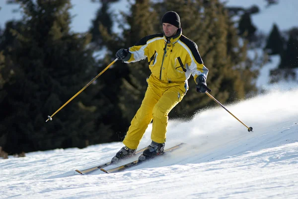 Esquiador amarelo na pista de esqui — Fotografia de Stock