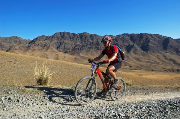 Mountainbiker op oude weg in woestijn — Stockfoto