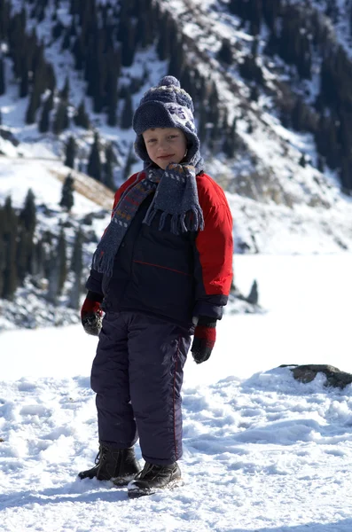 Jongen en winter bergen — Stockfoto