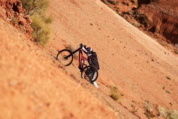 Extrembiker bergauf in roter Schlucht lizenzfreie Stockfotos