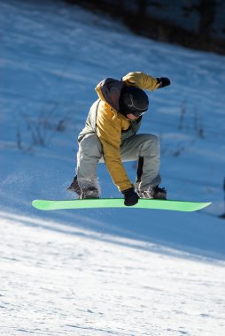 Yeşil tahta üzerinde uçan snowboarder