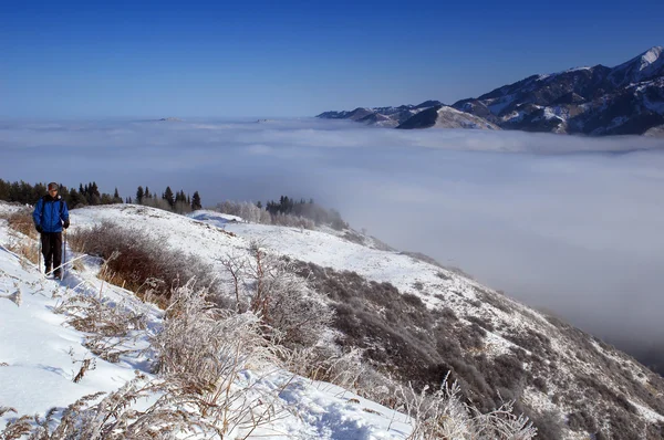 Man snowshoer klättring ovan molnen — Stockfoto
