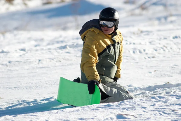 Snowboarder senta-se em declive na expectativa de — Fotografia de Stock