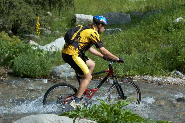 Ciclista de montaña y arroyo — Foto de Stock