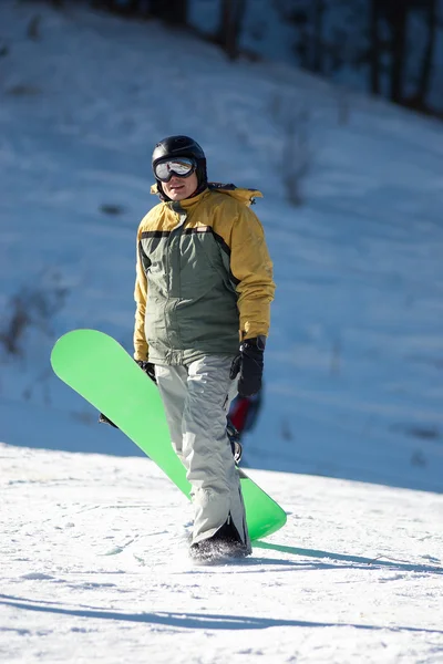 Snowboarder and green board — Stock Photo, Image