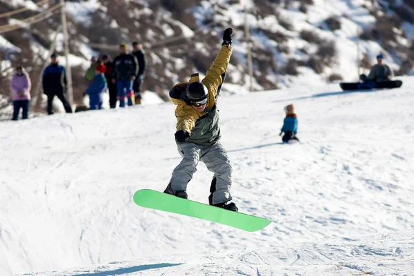 Vliegende snowboarder op groen bord — Stockfoto