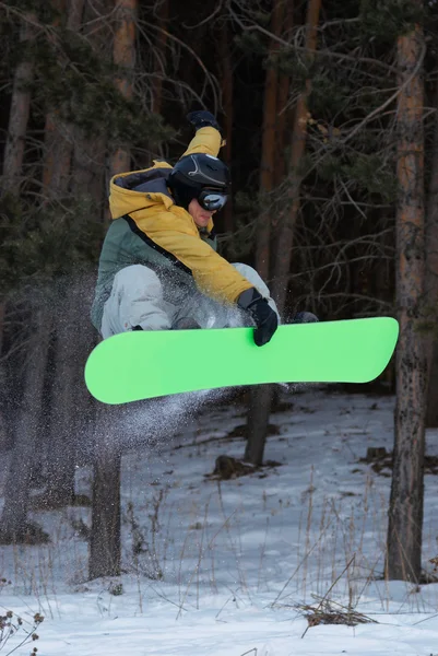 Летающий сноубордист на зеленом борту — стоковое фото