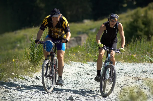 Dos ciclistas en carretera de alta montaña — Foto de Stock