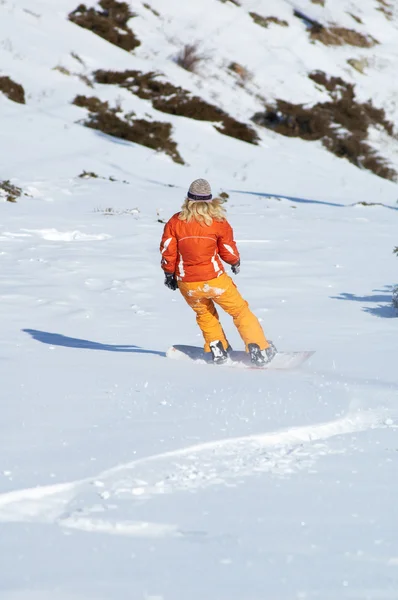 Orangefarbenes Snowboard Mädchen bergab — Stockfoto