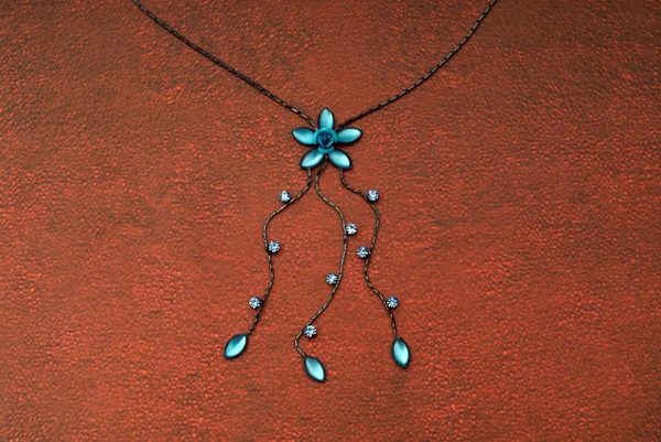 Голубое ожерелье и коричневая текстура — стоковое фото
