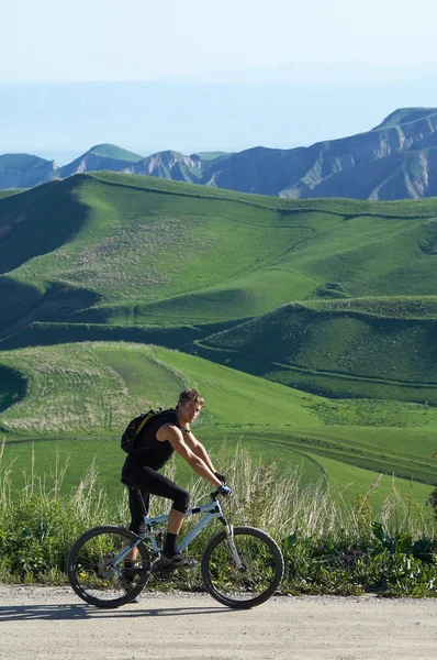 Motociclista e colina verde — Fotografia de Stock