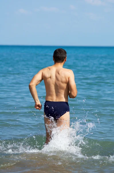 Человек идет в воду — стоковое фото