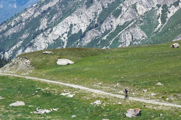 Motociclista su strada rurale di alta montagna — Foto Stock