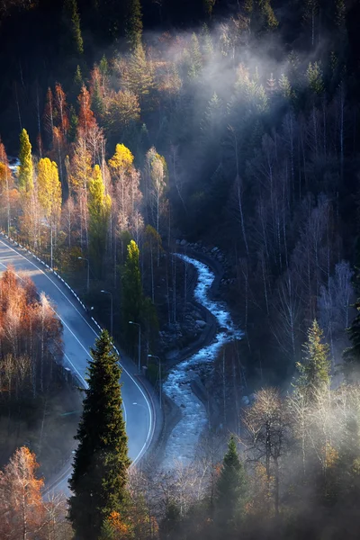 Road and river in autumn mountains — Stock Photo, Image